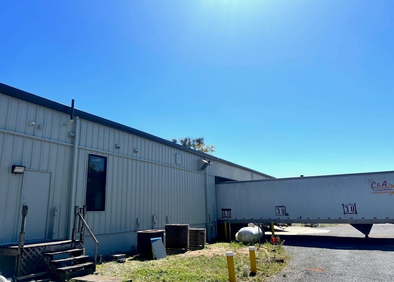 Same commercial building after a full exterior repaint in cream with a black roof line